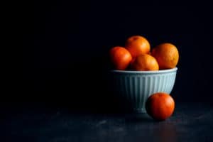 orange fruit in white ceramic bowl