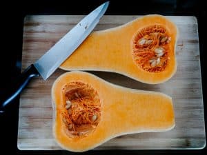 stainless steel knife on brown wooden chopping board, squash