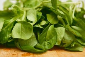 green spinach leaves on brown wooden table