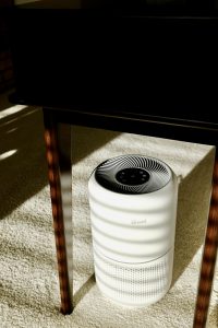 a white air conditioner sitting under a table